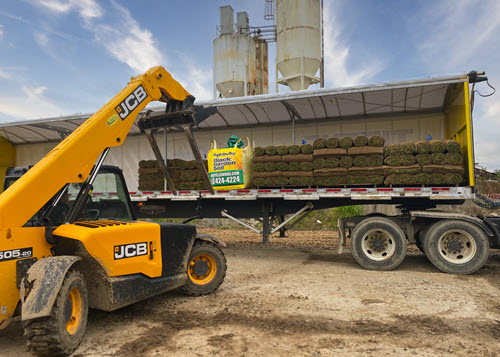 Loading pallets of Sod and a bag of compost on a Super-Sod truck