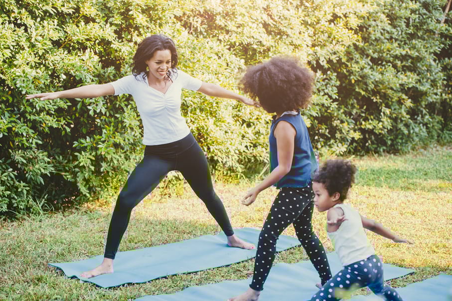 Family doing yoga on the lawn