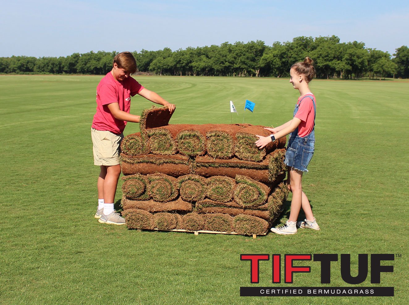 kids showing rolls of Tiftuf on a pallet